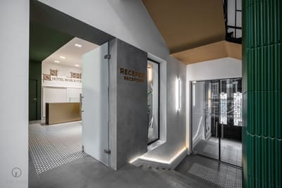 Recepciótér burkolt tömbbel és bordázott zöld térelválasztóval