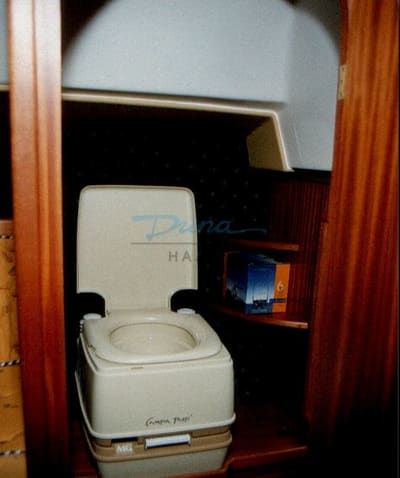 A mosdófülke belseje: hordozható wc, polcok, mahagóni burkolat